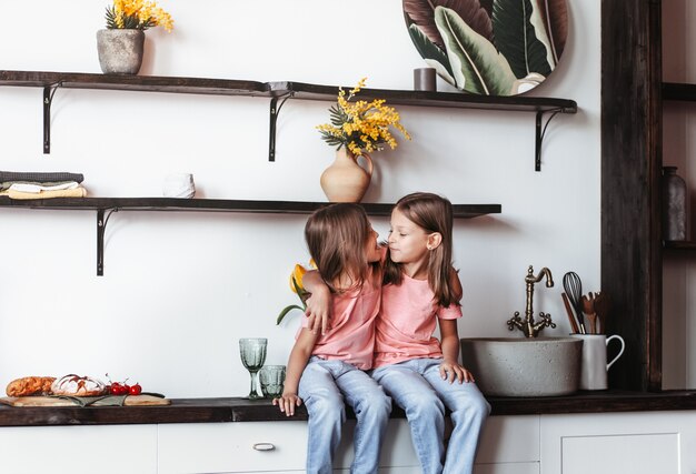 Dos hermanas de niñas se divierten juntas en la cocina