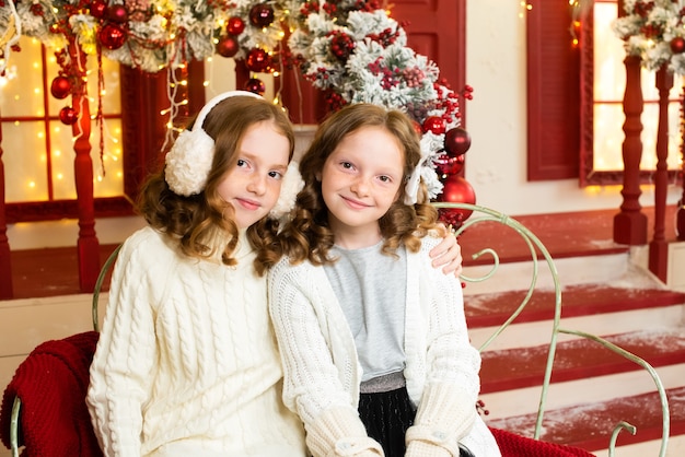 Dos hermanas pelirrojas en la terraza de una casa decorada para Navidad