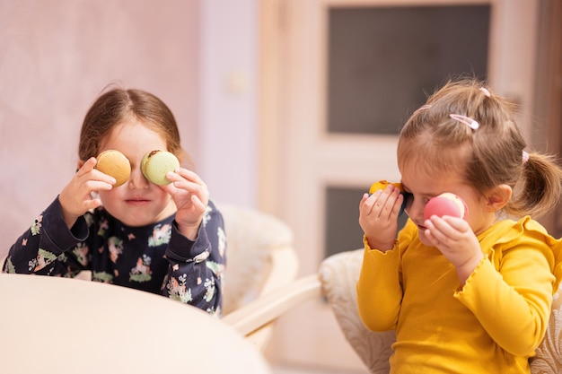 Dos hermanas se ponen los ojos deliciosos y sabrosos macarrones de color dulce