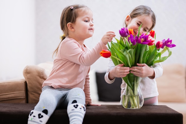 Dos hermanas con ramo de tulipanes de primavera Decoración navideña con flores tulipanes coloridos