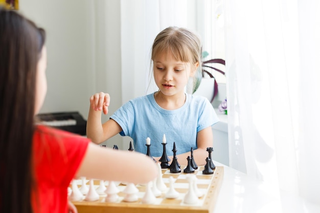 Dos hermanita jugando al ajedrez en casa