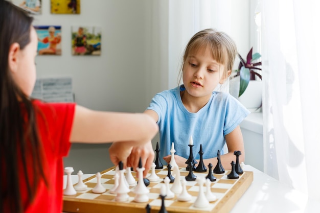 Dos hermanita jugando al ajedrez en casa