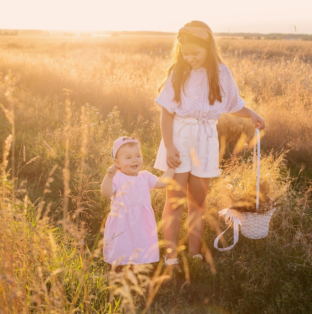 Dos hermanitas en el campo de verano al atardecer