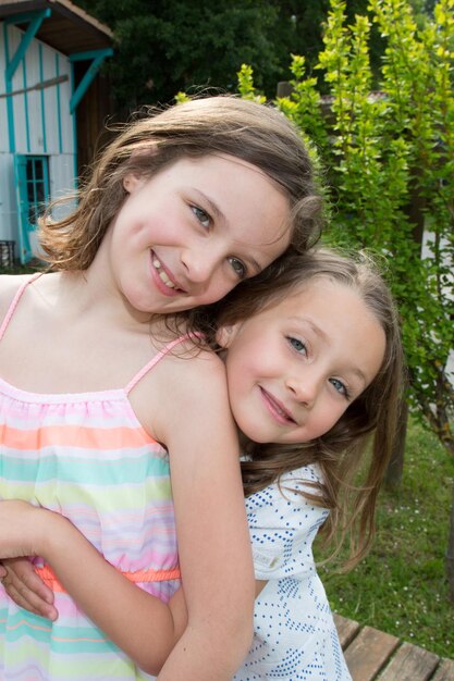 Dos hermanitas felices aman y abrazan en un hermoso parque