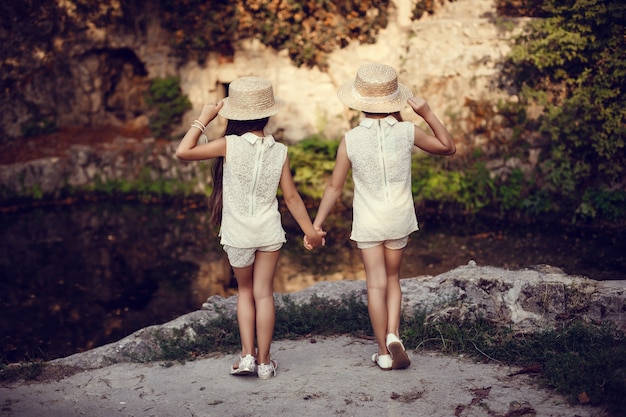 Dos hermanitas felices aman y abrazan en el hermoso parque.