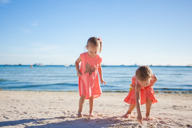 Dos hermanitas jugando juntas en la playa blanca