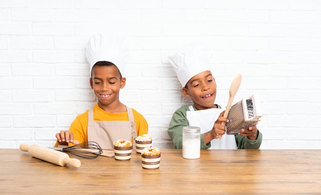 Dos hermanos afroamericanos niños vestidos como chef