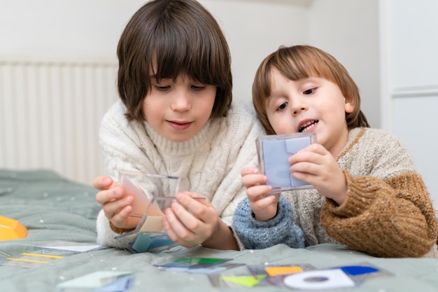 Dos hermanos jugando juegos inteligentes de desarrollo en casa Hermanos pasando tiempo juntos resolviendo juguetes lógicos