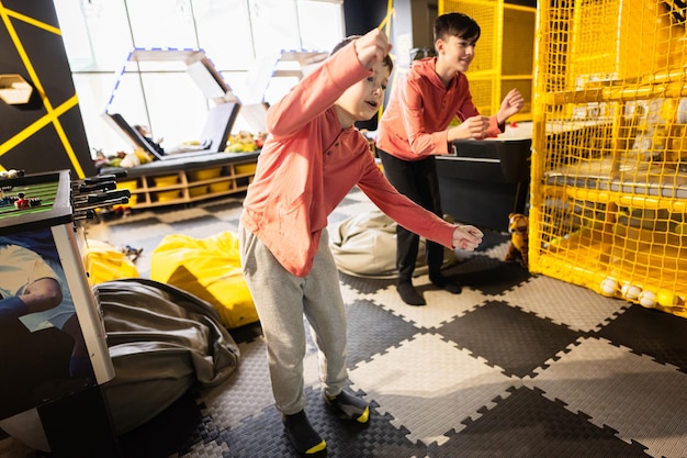 Dos hermanos montando con una moderna consola de videojuegos por sensor en el centro de juegos para niños