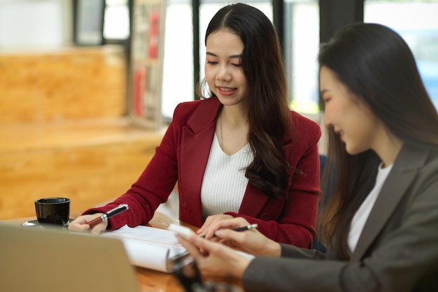 Dos de la hermosa joven contable estiman y calculan el estado comercial para el próximo trimestre. concepto de trabajo en equipo