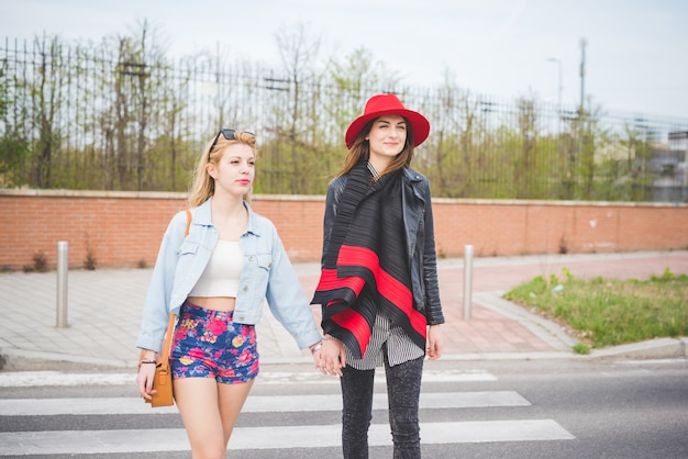 dos hermosa rubia y morena chica divirtiéndose en la ciudad