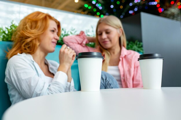 Dos hermosas amigas se sientan en un café después de sus compras durante las rebajas.