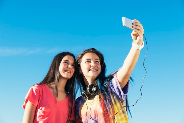 Dos hermosas chicas adolescentes tomando Selfie en el parque