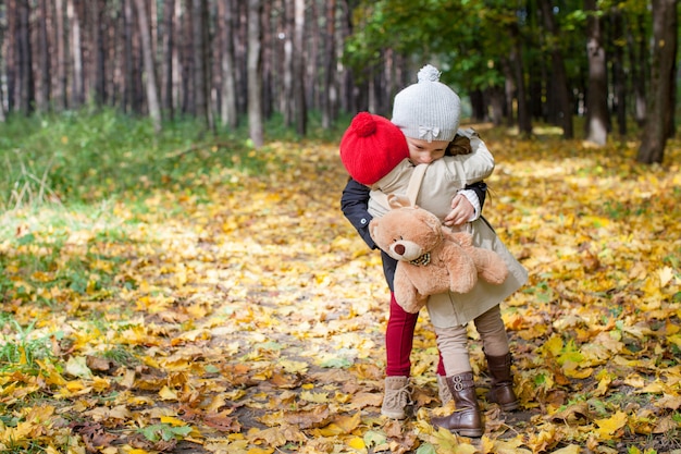 Dos hermosas chicas adorables disfrutando y divirtiéndose en el cálido y soleado día de otoño