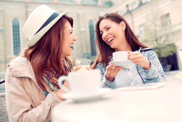 Dos hermosas chicas jóvenes sentadas en un café