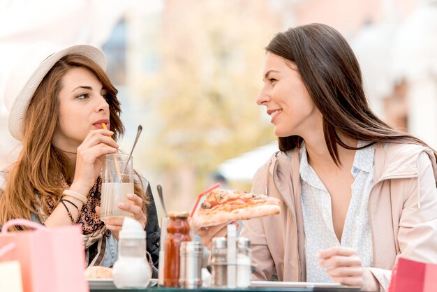 Dos hermosas chicas jóvenes sentadas en un café