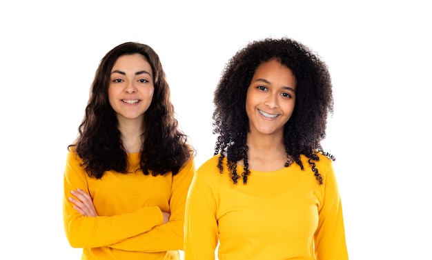 Dos hermosas chicas jóvenes con suéteres de colores aislados en un blanco