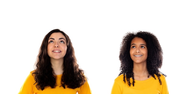 Dos hermosas chicas jóvenes con suéteres de colores aislados en un blanco