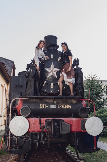 Dos hermosas chicas con ropa steampunk en el fondo del tren