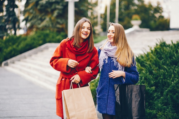 dos hermosas y elegantes novias caminando por la ciudad con paquetes y compras