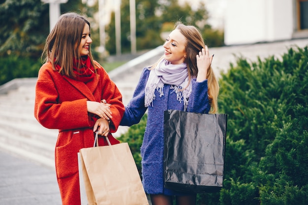 dos hermosas y elegantes novias caminando por la ciudad con paquetes y compras