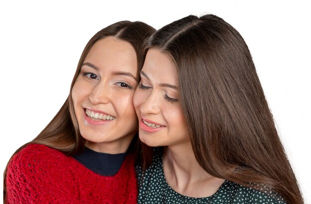 Dos hermosas hermanas abrazándose y sonriendo