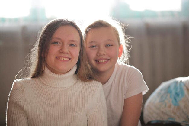Dos hermosas hermanas rubias sonriendo con ropa blanca