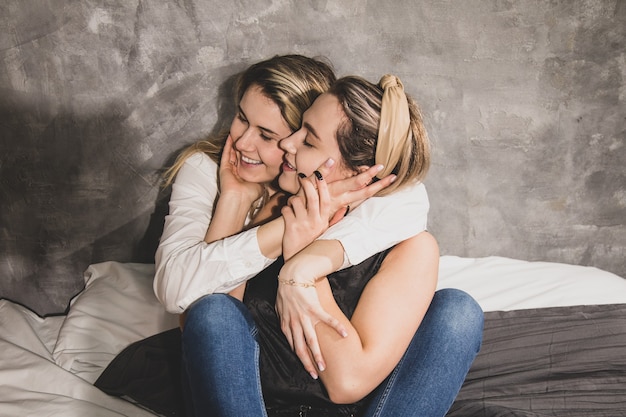 Foto dos hermosas mujeres se abrazan en la cama, felices juntas. lesbianas de minorías sexuales