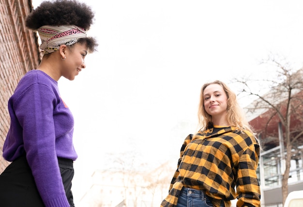 Dos hermosas mujeres africanas y caucásicas, con bandera del orgullo gay