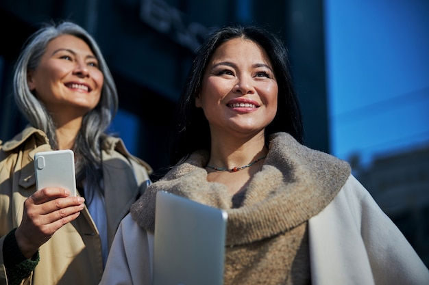 Dos hermosas mujeres alegres de pie en la calle