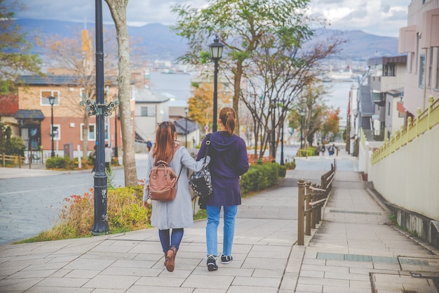 Dos hermosas mujeres caminando por la calle en Hachiman-zaka slop, Hokkaido, Japón