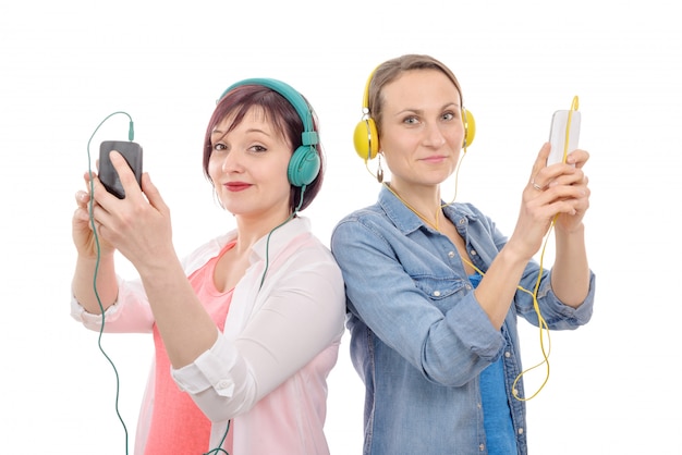 Dos hermosas mujeres escuchando música con teléfono