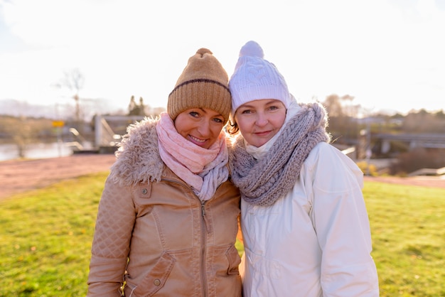 Dos hermosas mujeres maduras juntas contra la vista panorámica de la naturaleza