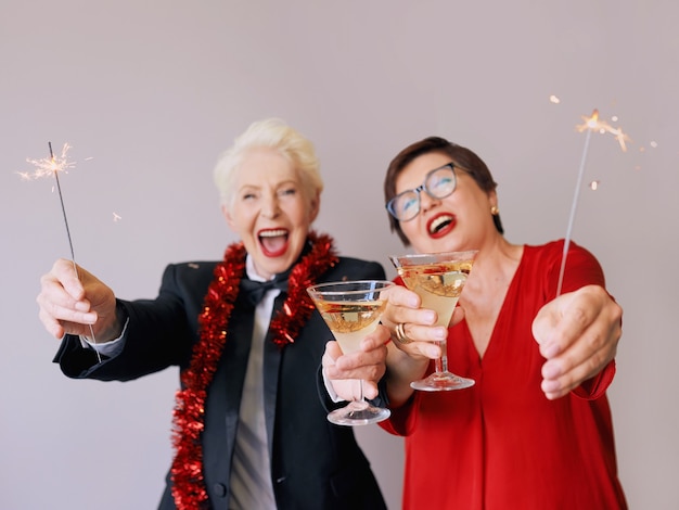 Dos hermosas mujeres mayores maduras con estilo celebrando el año nuevo