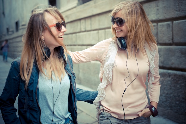 dos hermosas mujeres rubias caminando y hablando