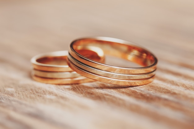 Dos hermosos anillos de boda en mesa de madera