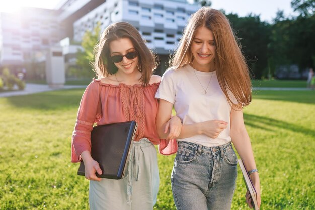Dos hermosos estudiantes adolescentes caminan juntos después de clase