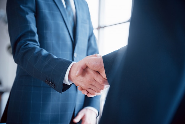 Dos hombre de negocios confía en estrecharme la mano durante una reunión en la oficina, saludo y concepto de socio