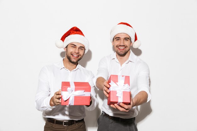 Dos hombres alegres elegantemente vestidos que se encuentran aisladas sobre un espacio en blanco, celebrando el Año Nuevo