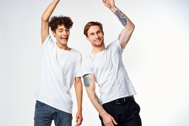 Dos hombres con camisetas blancas están de pie junto a las emociones de la amistad.