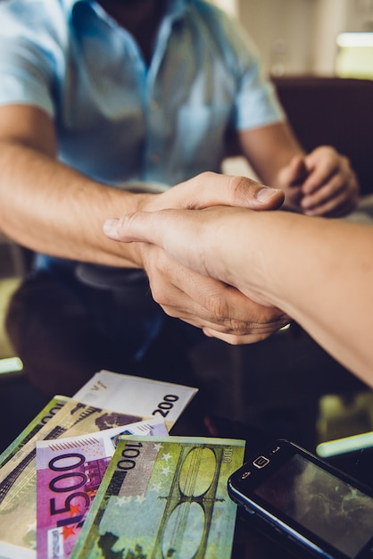 Foto dos hombres dándose la mano en el café.