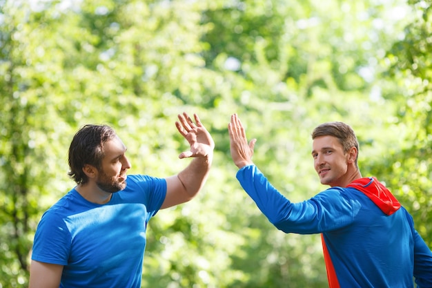 Dos hombres después de hacer ejercicio al aire libre dando cinco