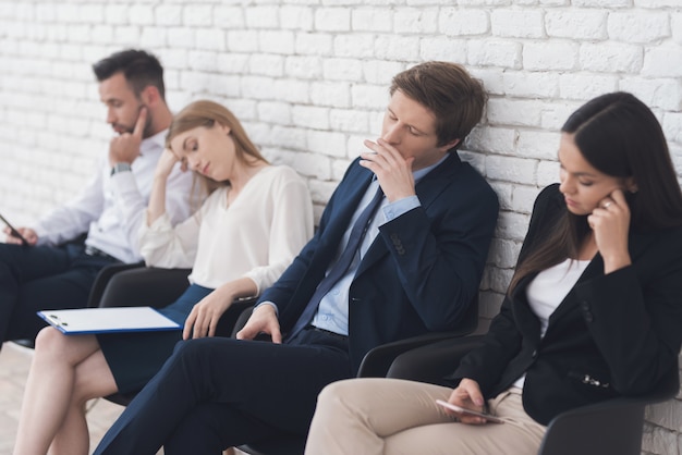 Dos hombres y dos mujeres seguras están esperando.