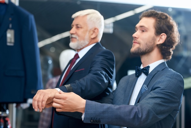 Dos hombres elegantes eligiendo disfraces.