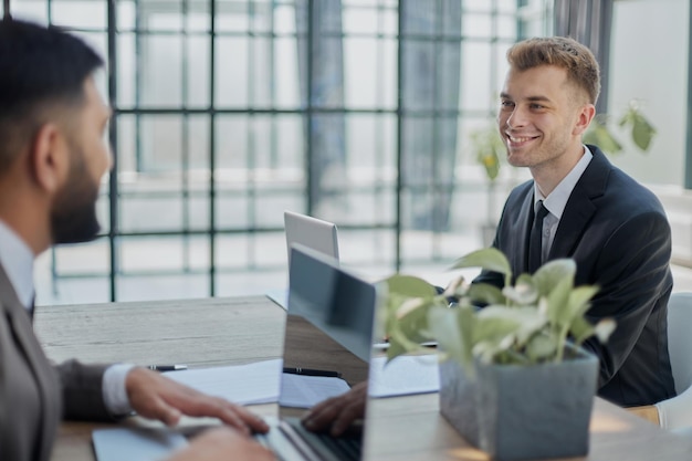 Dos hombres felices trabajando juntos en un nuevo proyecto empresarial