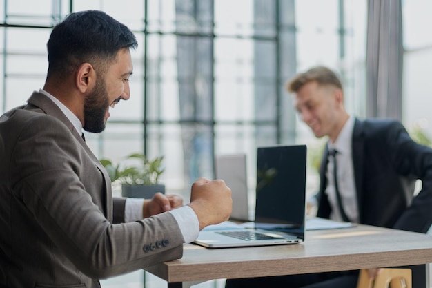 Dos hombres felices trabajando juntos en un nuevo proyecto empresarial