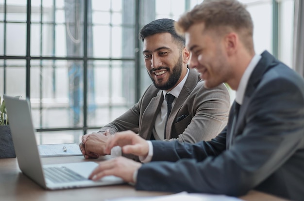 Dos hombres felices trabajando juntos en un nuevo proyecto empresarial