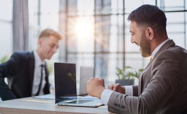 Dos hombres felices trabajando juntos en un nuevo proyecto empresarial