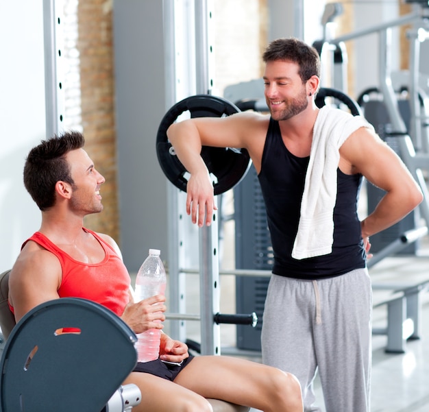 Dos hombres en un gimnasio deportivo relajado después de fitness