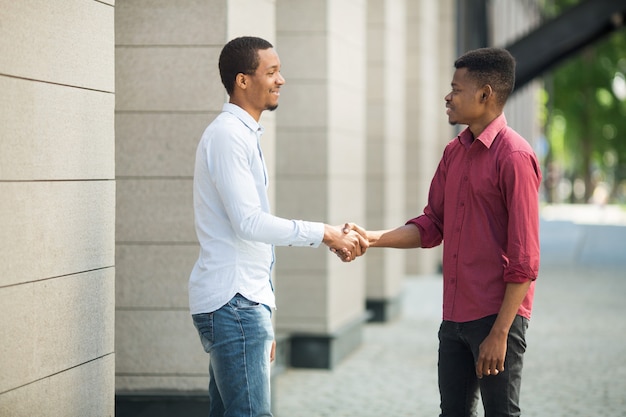 dos hombres guapos en camisas dándose la mano